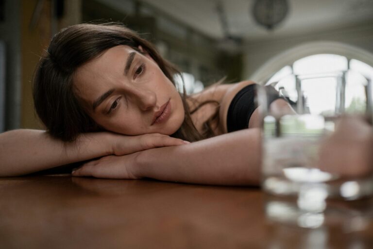 Woman resting her head on a table while considering whether abortion is her only pregnancy option.
