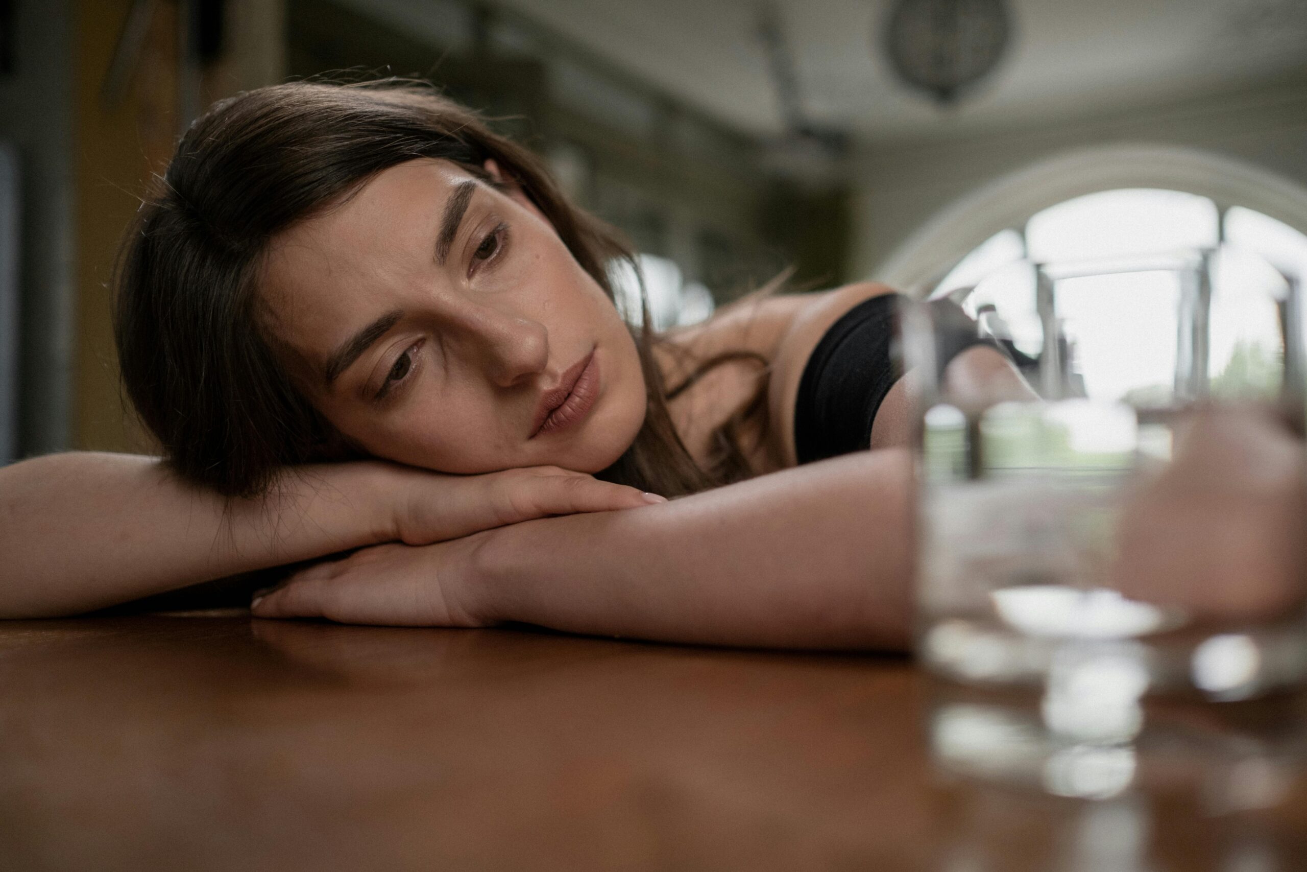 Woman resting her head on a table while considering whether abortion is her only pregnancy option.